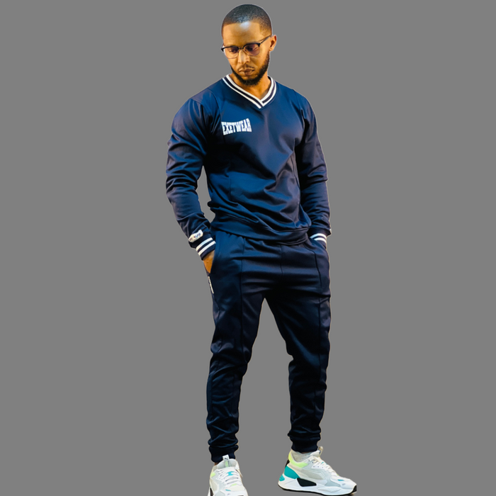 Image of a Men's Tech Fleece Sweatsuit in Navy Blue. The sweatshirt features navy blue stripes on the V-neck and cuffs, with a minimal logo.